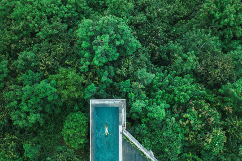 Drone aerial shot of woman relaxing in awesome infinity swimming